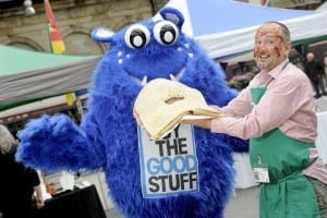 FREE PICTURE: Monster Jeely Piece Challenge at Edinburgh Social Enterprise Network's "Eat The Good Stuff" Launch, Fri 9/10/15: Master-Piece: jam-maker Craig McCormack from Tiphereth (correct) Trading social enterprise group gets a bite of the Monster Jeely Piece Challenge. Pictured with ESEN mascot Dougie GoodStuff. The UK's largest jelly piece (jelly sandwich) is unveiled by master foodcrafters and Edinburgh Social Enterprise Network (ESEN) at Edinburgh's Waverley Station Market, to promote Edinburgh’s food social enterprises and their “Eat the Good Stuff” campaign. The Monster Jeely Piece Challenge is launched by ESEN with Breadshare and Tiphereth in a Jar at Waverley Station's “LocalMotive Markets” site, alongside platform 2 where the new Borders Railway starts and finishes. The monster sani is 1.8m x 1.6m large , and is made with 12 kilos of organic strawberry jam. It was later cut up into 768 individual sandwiches to share with rail travellers, staff and passers-by. More information from: Fiona Stewart, InterWoven PR - 07940 560 453 - fiona@booktrawler.com Photography from: Colin Hattersley Photography - colinhattersley@btinternet.com - www.colinhattersley.com - 07974 957 388