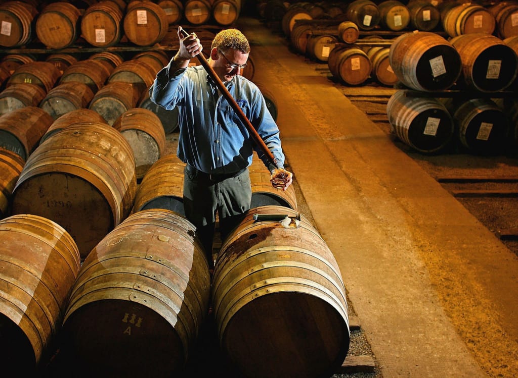 A worker at Bruichladdich distillery takes a whisky sample from a single cask. Picture: Getty 