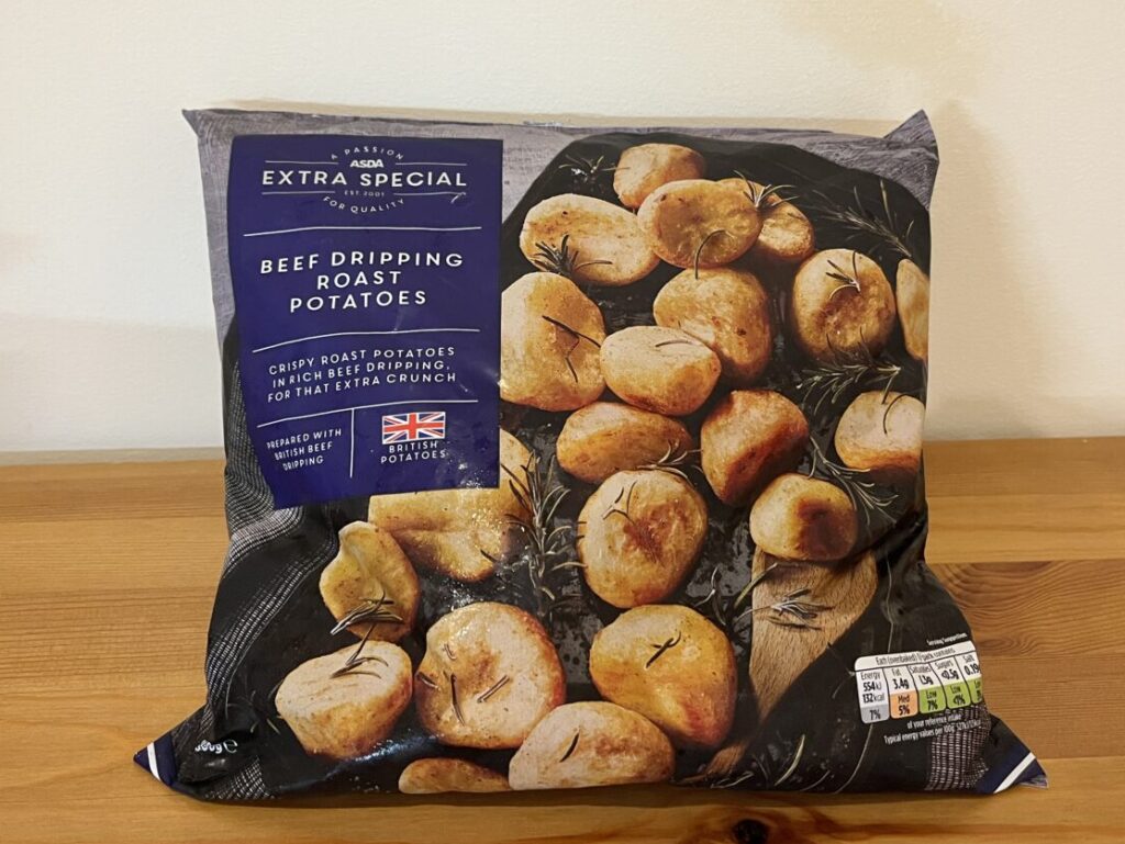 A bag of Asda Extra Special 2023 Beef Dripping Roast Potatoes sitting on a table